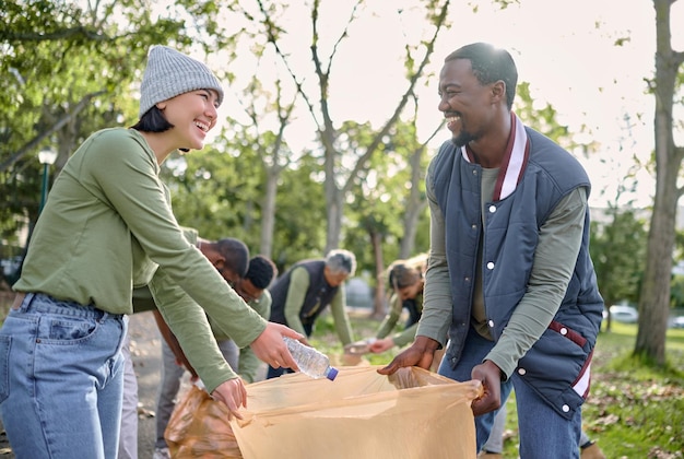 コミュニティ ボランティアのチームワークとクリーンな環境のためのゴミ袋とプラスチックの公園の清掃 多様性の男性と女性は、エコ フレンドリーなライフ スタイルと自然の中での屋外のリサイクルのためのゴミを助ける