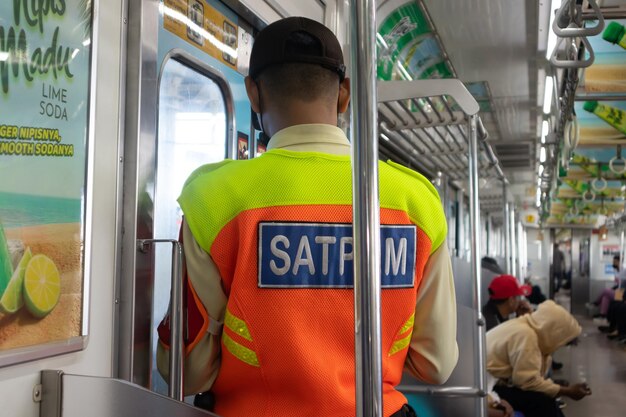 Commuter line security officer in train carriage standing in front of the train door