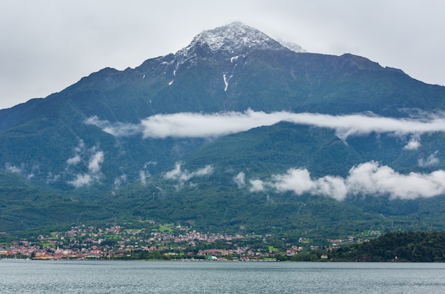 Comomeer (Italië) zomer bewolkt uitzicht met sneeuw op de bergtop