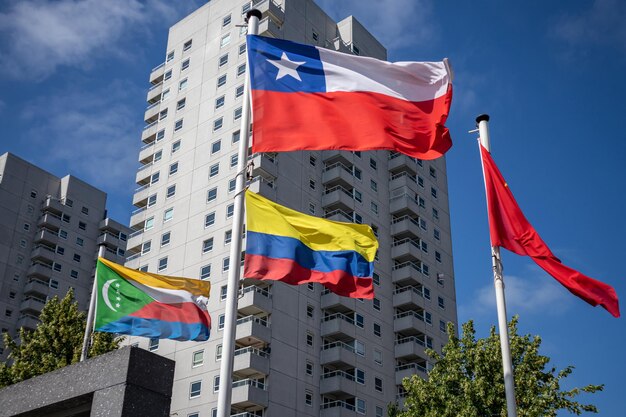 Comore colombia cile bandiere sventolanti contro grattacieli e cielo blu