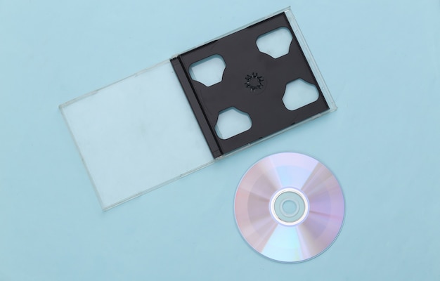 Compact disc with box on a blue background. Top view, minimalism