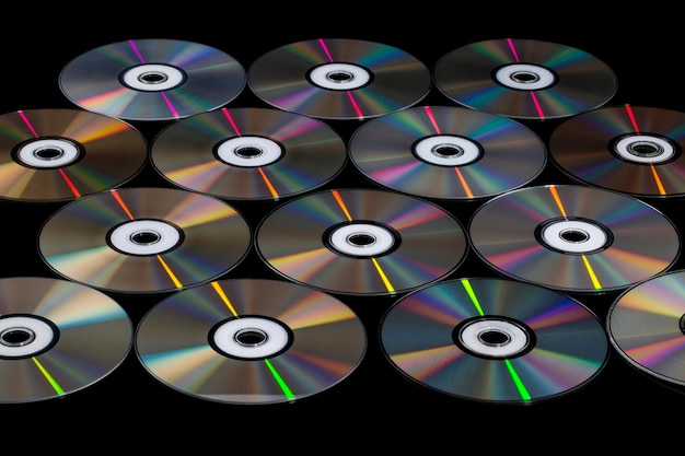 Compact discs on a black background with color reflection