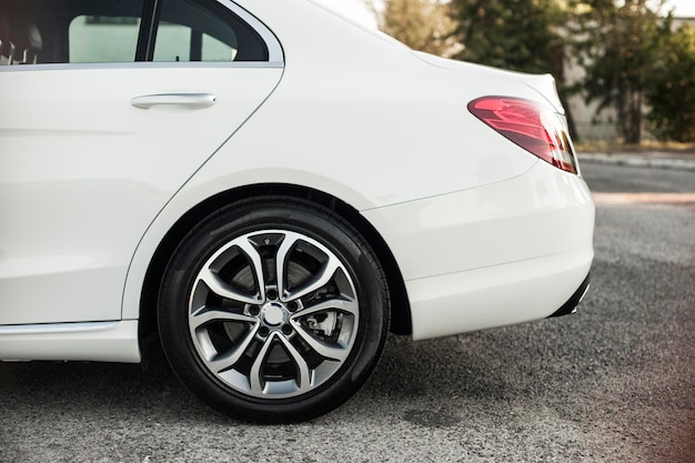 Compact white executive car, with beautiful wheels, large chrome grille.