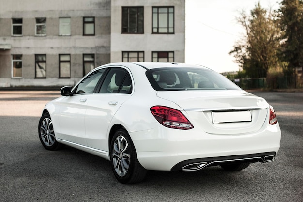 compact white executive car, with beautiful wheels, large chrome grille.