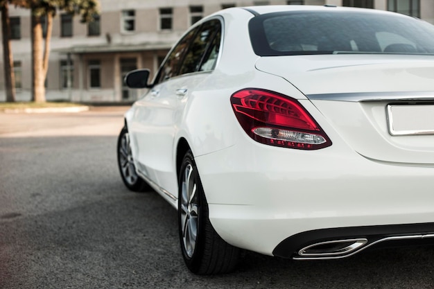 compact white executive car, with beautiful wheels, large chrome grille.