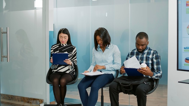 Company employee giving cv resume to people waiting in lobby,
getting ready to attend job interview with hr worker. job
candidates feeling nervous about hiring meeting and selection.