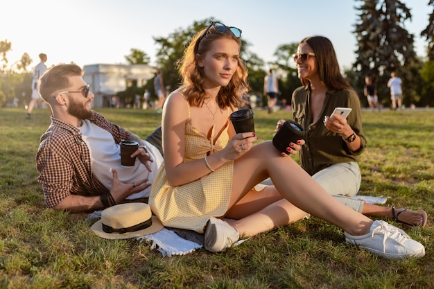 Photo company of friends having fun together in park listening to music