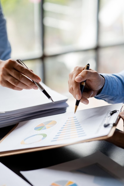 Company meeting room has businessmen and finance managers meeting together on finance topics they are looking at information on documents and discussing together Concept company financial management