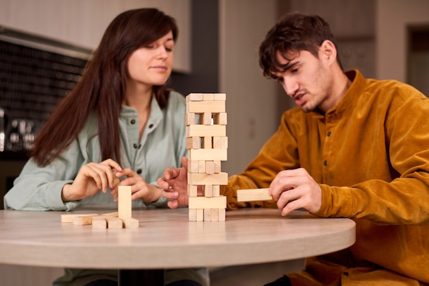 Company of young people plays table game at home