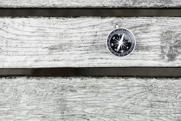 Compass on a beautiful wooden surface. Top view