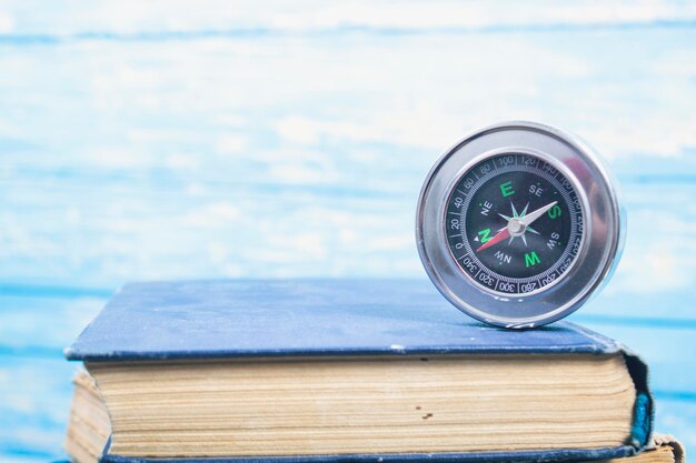 Compass on a book on a blue background. concept orientation