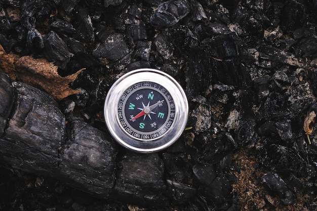 Compass on coals of an extinguished firepicnic recreation and adventures in wild