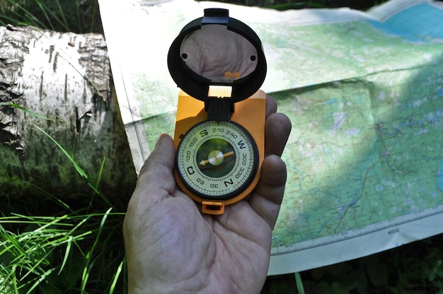 Compass in hand against background of the map