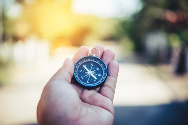 Compass in the hand. Tourists hold a compass and locate a place