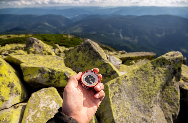 Compass in the hands in the Carpathian mountains Traveling in the mountains