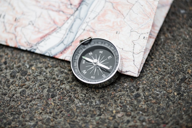 Compass and map on the asphalt