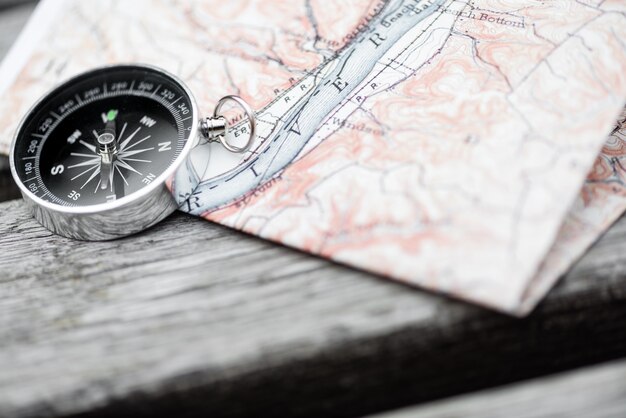 Compass and map on a beautiful wooden surface. Top view