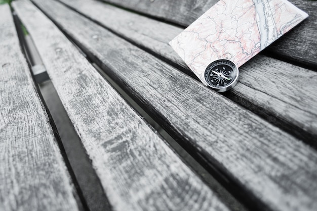 Compass and map on a beautiful wooden surface. Top view