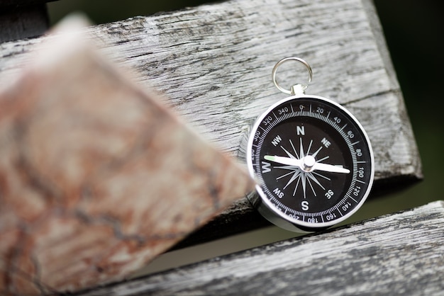 Compass and map on a beautiful wooden surface. Top view