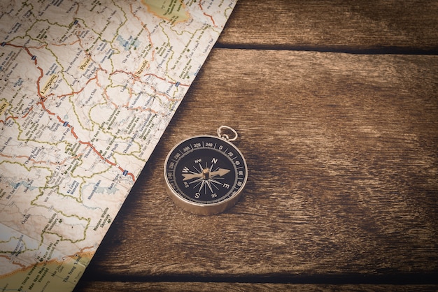 Compass and map on wooden table