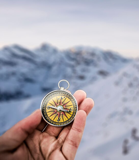 Foto direzione di viaggio di navigazione della bussola mano con la bussola alla montagna