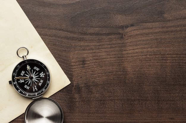 Photo compass and old paper on the brown wooden table