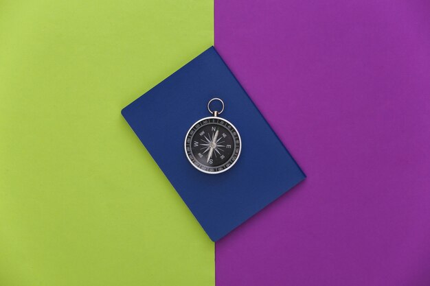 Compass and passport on purple green background. Top view. Minimalism travel concept. Flat lay