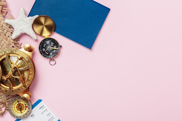 Compass on pink background, top view