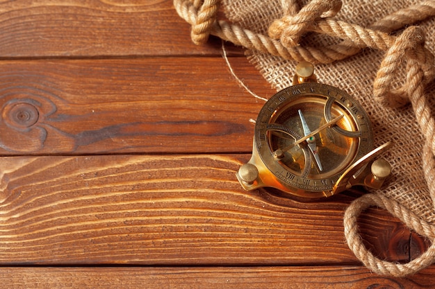 Compass and rope on old wooden boards