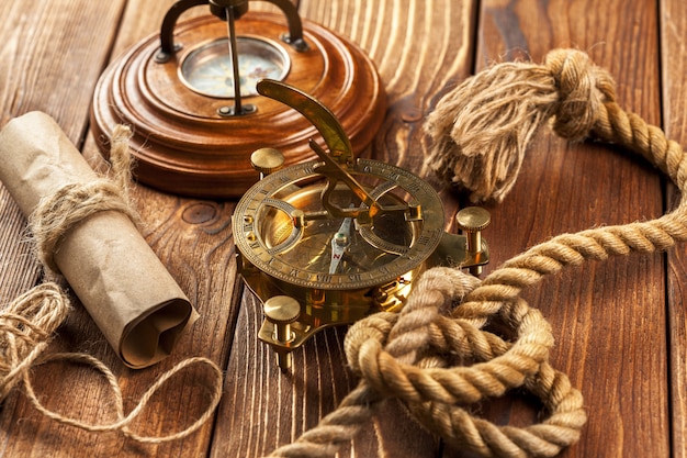 Compass and rope on wooden table. close up