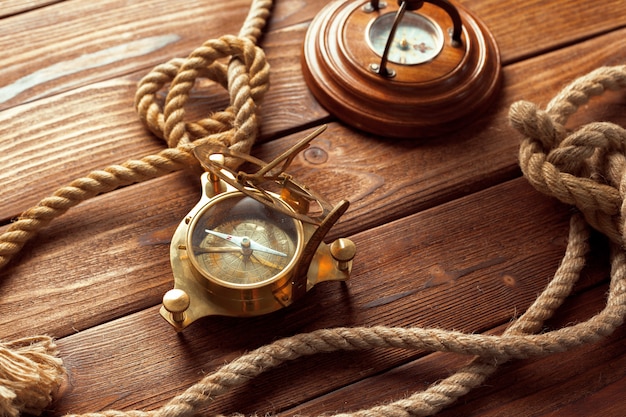 Compass and rope on wooden table. close up