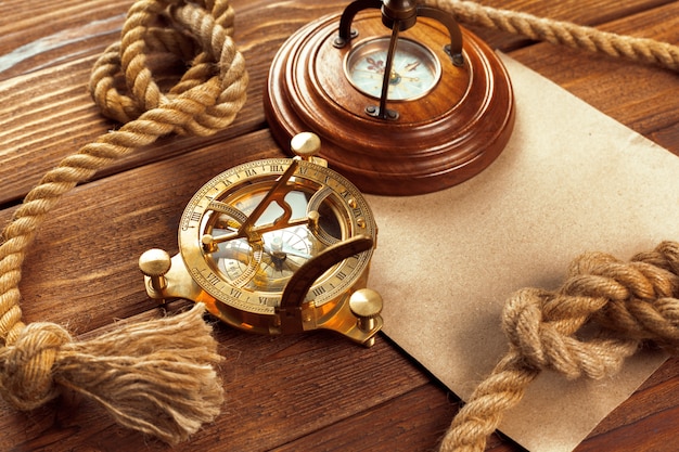 Compass and rope on wooden table. close up