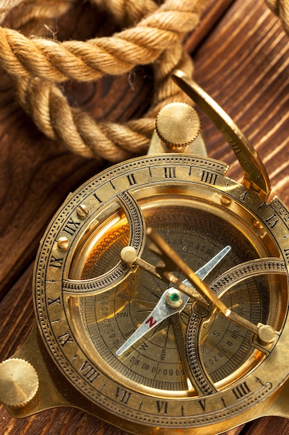 Compass and rope on wooden table.