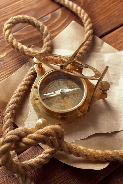 Compass and rope on wooden table