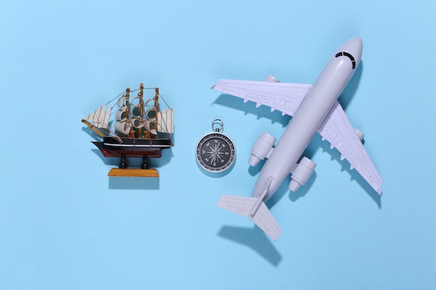 Compass, ship and air plane on bright blue