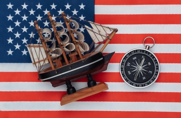 Photo compass and ship on usa flag close up. top view
