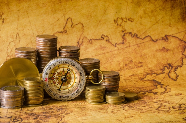 Compass and stack of coins on old map