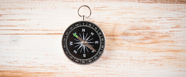 Compass on a wooden scene with a white shade