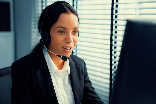 Competent female operator working on computer and while talking with clients