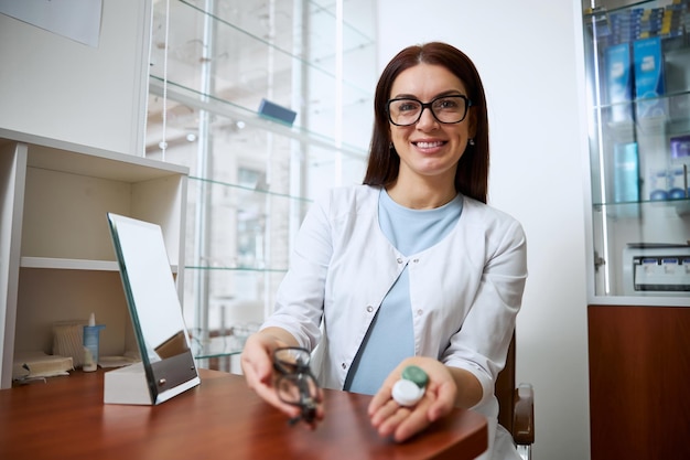 Competent ophthalmologist demonstrating a set of contacts and glasses