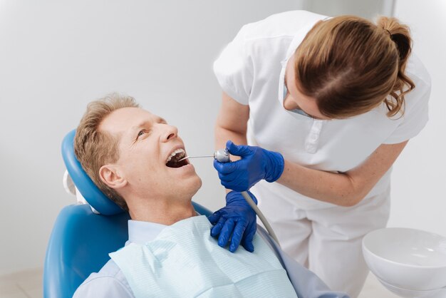 Competent trained local doctor applying her experience for treating the patient using modern equipment in her office