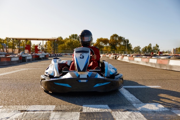 Competitieve man racen in gocarts aan de finish van een racebaan