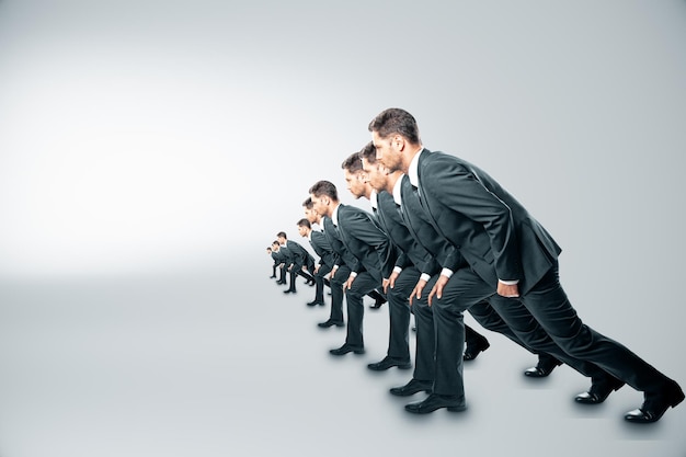 competition concept with businessmen about to run on grey background