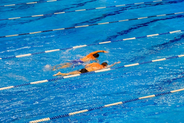 Competition in a swimming pool Two swimmers trying to overtake each other Sports healthy lifestyle concept