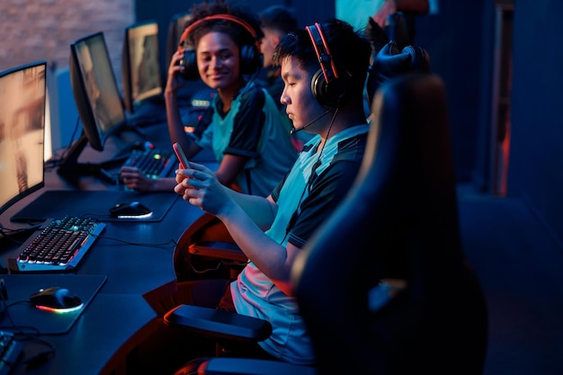 Competitive gamer playes on smartphone in cyber club