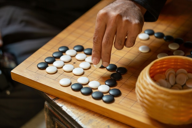  A competitor is placing a marble piece on a Go board game.