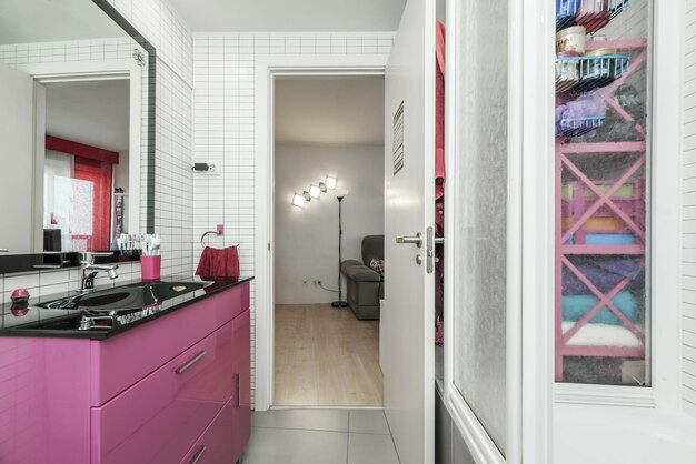 Полная ванная комната с розовой тумбой под умывальник