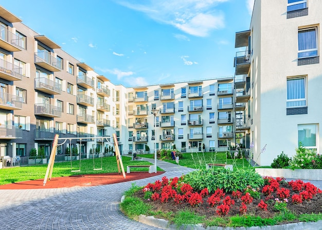 Complex van nieuwe appartementsgebouwen met kinderspeeltuin en bloempot als buitenvoorzieningen.