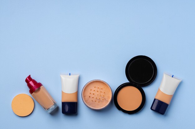 Complexion make up products and brush on blue