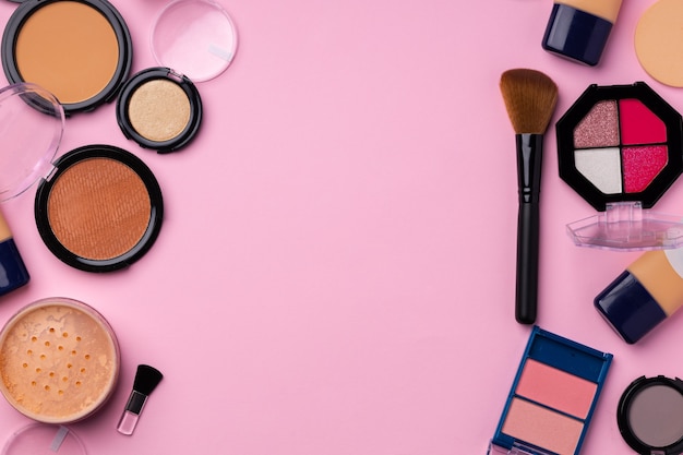 Complexion make up products and brush on pink